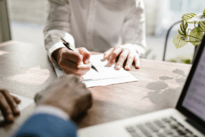 Directeur commercial et experts en négociation discutant dans un bureau, illustrant les tensions entre industriels et grande distribution lors des négociations commerciales.